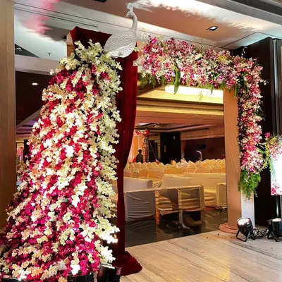 This entrance features a large peacock sculpture I crafted from pink and white flowers, connected to a matching floral arch. It creates a stunning welcome for wedding guests.