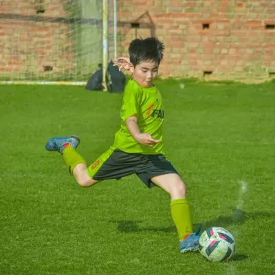 A young player from our academy strikes the ball with perfect form and power. We focus on teaching strong fundamentals from an early age.