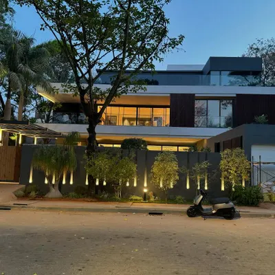 We designed this modern luxury residence in Bangalore to make a statement, especially at dusk. The strategic exterior lighting highlights the clean architectural lines and interplay of volumes, creating a warm and inviting facade.