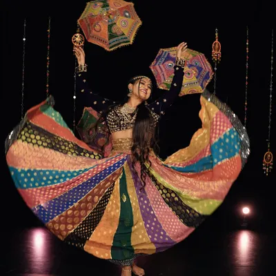 The pure joy of Garba. A candid shot capturing the twirl of my multi-colored lehenga, a key element of Navratri performances. The vibrant colors and flowing fabric add to the visual spectacle of the dance.