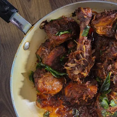 This is my Amma's style of Chicken Roast. I learned to make it simply because I loved to eat it. It features succulent chicken pieces cooked down in a thick, caramelized onion gravy and garnished with curry leaves.