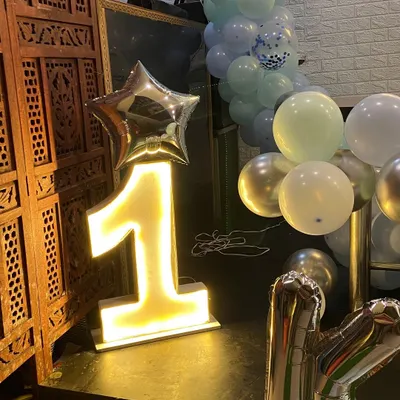To make milestone birthdays stand out, I provide large, light-up marquee numbers. This glowing number '1' adds a professional and eye-catching element to a first birthday party, perfect for photos.