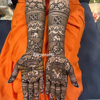 A classic bridal design featuring bands of traditional motifs, including elephants, paisleys, and a doli scene, creating a rich story on the arms.