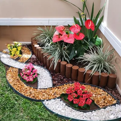 A beautiful example of mixed-media landscaping. We used wooden log borders, river pebbles, and colorful flowers to create this intricate and artistic garden corner.