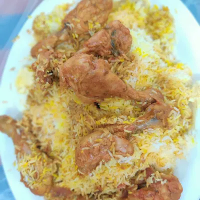 A classic plate of our chicken biryani, piled high with tender chicken drumsticks and flavorful rice. This is the authentic taste we've been serving since 1996.