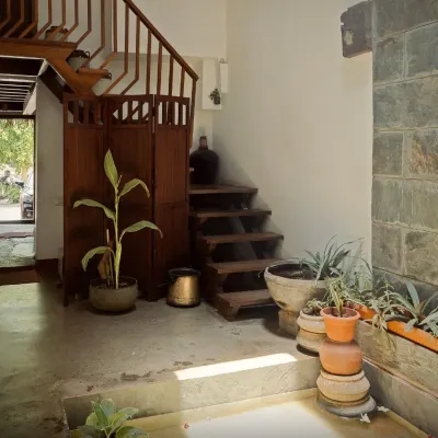 The entrance to the restored Mattur residence, a 200-year-old ancestral home. The design transforms a compact 10ft wide space into a grand narrative of light and tradition, using natural materials like stone and wood.