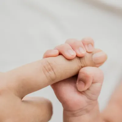 The strength in that tiny grip. A newborn holding onto a parent's finger is a classic, powerful image of connection and trust.