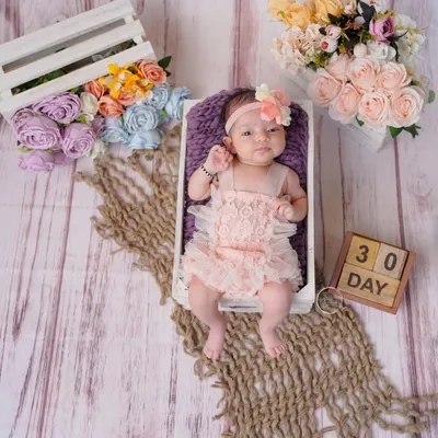 Celebrating 30 days of sweetness. This newborn portrait uses a miniature crate and floral accents to create a beautiful, rustic composition.
