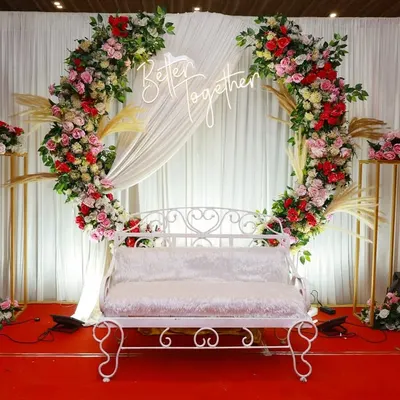 This elegant anniversary stage combines a floral ring backdrop with custom neon signage and classic seating. We focus on creating a picture perfect focal point for your celebration, ensuring every photo captures the magic of the moment.