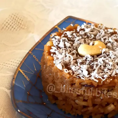 My Gur Wale Chawal (jaggery rice), a classic North Indian dessert that is both healthy and delicious. It's garnished with shredded coconut and a cashew for a final touch.