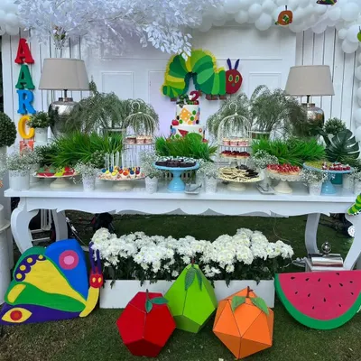 Here is a full view of the dessert table for 'The Hungry Caterpillar' party. I created the caterpillar cake topper, the colorful butterfly, and the 3D fruits to tie the entire setup together, making the food display a part of the story.