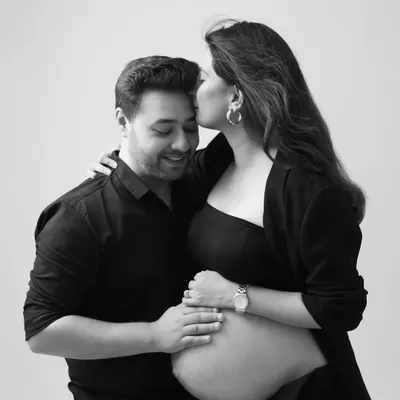 A tender moment captured in a modern style. This black and white portrait featuring a chic blazer look is both intimate and fashionable.