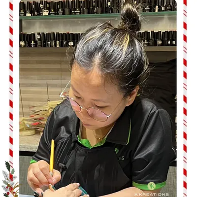 Our talented nail technician, Zingranphy, meticulously crafting a festive nail design with precision and artistry.
