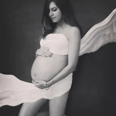 Simply divine. This black and white studio portrait uses a simple satin drape to create a classic, artistic photo that beautifully highlights the baby bump.