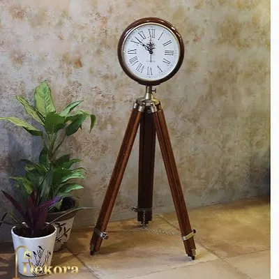 Our wooden tripod clock shown next to indoor plants, highlighting its natural materials and suitability for creating a warm, inviting corner.