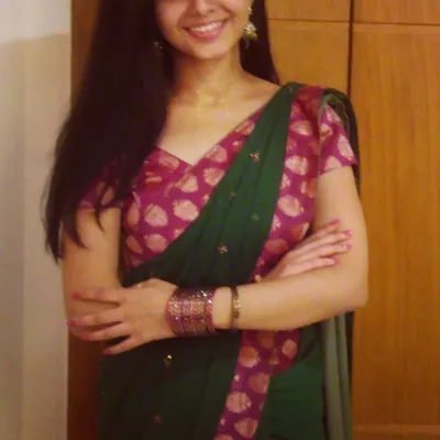 A happy client wearing a custom look for a family function. I designed a rich pink brocade blouse to complement her classic green saree, adding a pop of color and traditional elegance.