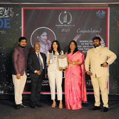 On stage accepting the Pride India Award for 'Women Leader of the Year'. This moment celebrates the fusion of ancient healing practices with modern wellness, a philosophy I bring to every client session.