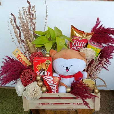 This cute and compact hamper is perfect for any occasion. It features a plush toy, snacks like Pocky and Maltesers, and is decorated with dried flowers for a rustic, charming look.