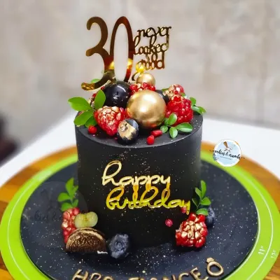 Milestone moments deserve a statement cake. This 30th birthday cake features a rich black buttercream, elegant gold script, and a topping of fresh berries for a touch of luxury.