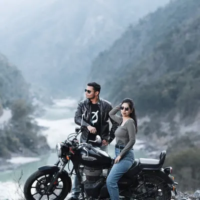 A classic biker couple pose against the stunning backdrop of the river and mountains near Rishikesh. The leather jackets and cool sunglasses complete the edgy, adventurous vibe of this pre-wedding shoot.
