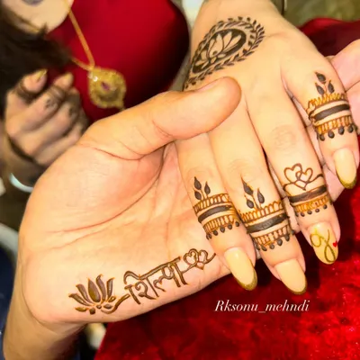 A beautiful moment between a couple, each getting a personalized mehndi design. She has his name on her hand, and he has hers, a simple yet powerful symbol of their bond.