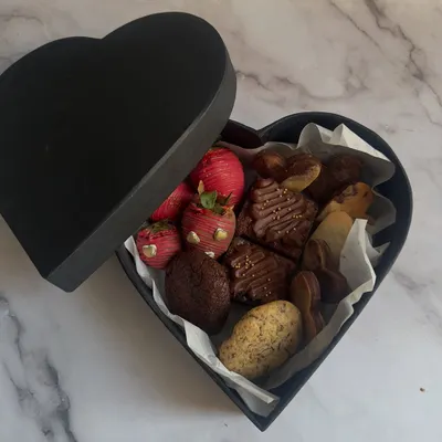 My Valentine's heart-shaped box is filled with an assortment of romantic treats. Inside, you'll find chocolate-dipped strawberries, fudgy brownies, and a selection of my gourmet cookies.