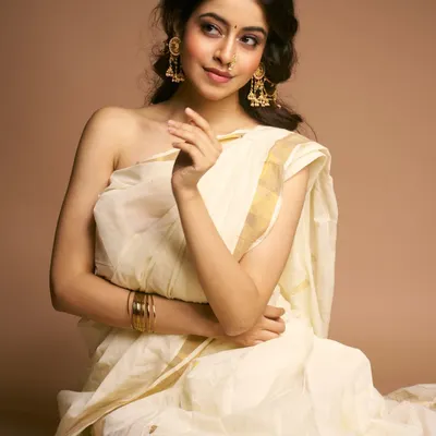 A moment of quiet grace. This look, inspired by classic Indian aesthetics, features soft makeup that enhances natural beauty, paired with a simple white and gold saree for a truly ethereal feel.