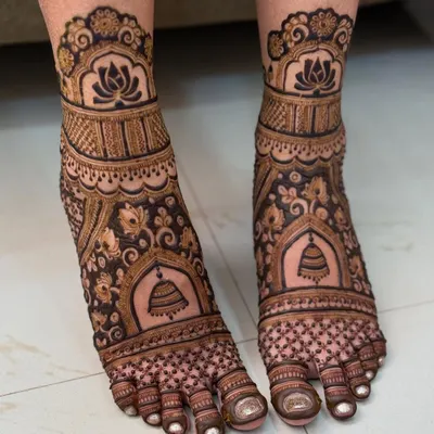 A classic bridal feet design featuring beautiful temple bells and lotus motifs. The patterns are symmetrical and create a stunning look, perfect for a traditional bride.
