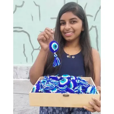 The artist with her art! This was my first-ever bulk order of 40 evil eye keychains for return gifts, a huge milestone for my small business.