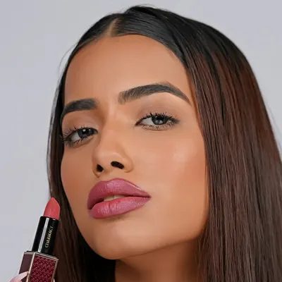 A striking close-up for a lipstick ad, showcasing a soft pink shade. The clean lighting and tight crop emphasize the product's texture and the model's features.