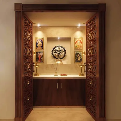 This pooja unit features beautifully CNC-carved doors and a contrasting color combination inside the mandir for a great view. The design is both traditional and elegant, creating a perfect space for prayer.