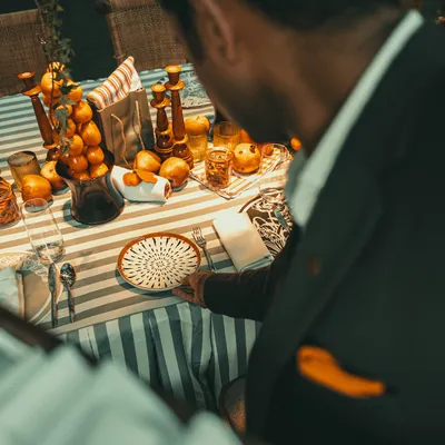 A guest admires an impeccably set table with a vibrant, citrus-themed decor.