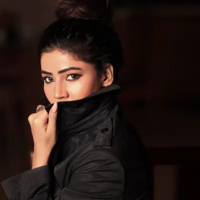 A mysterious and moody portrait with the collar of a trench coat pulled up. This style of headshot is great for creating a specific character or dramatic feel.