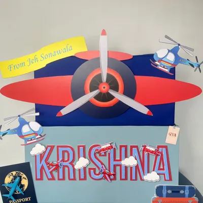 A full frontal view of the airplane-themed hamper for Krishna, showcasing the personalized name and various aircraft cutouts.