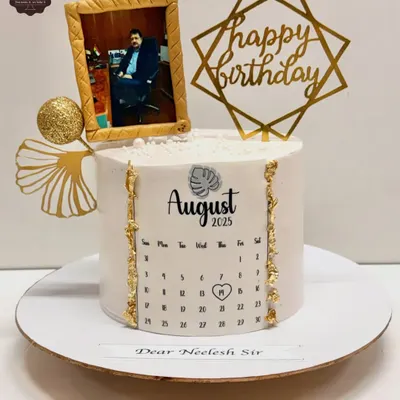 A unique birthday cake featuring a photo in an edible gold frame and a calendar marking the special day. This is a great way to create a personalized and memorable gift.