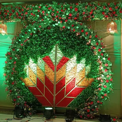 This is one of my most ambitious wedding backdrops, featuring a massive floral lotus design at its center. The entire structure is made of lush greenery and red roses, creating a breathtaking and grand entrance for the couple.