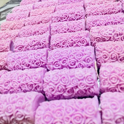 A large batch of lavender-scented candles, freshly made in a beautiful rose pattern. This shows how I can produce unique, molded candles in bulk for your event.