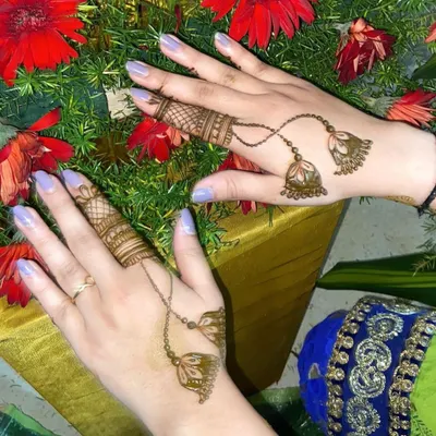 A creative and minimalist design featuring henna jhumkas (earrings) that appear to dangle from detailed finger bands.
