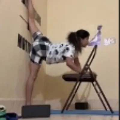 Using a chair, blocks, and the wall to work on a standing split variation. This setup provides stability and allows me to focus on the stretch.