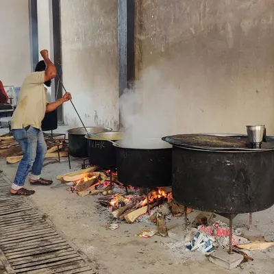 Here is one of my cooks stirring a large degh over a wood fire. This is the authentic, hands-on method I use for all my large-scale cooking.
