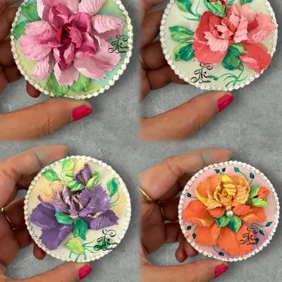 A beautiful collection of four 4-inch circular fridge magnets, each featuring a unique, colorful sculpted flower. These are perfect for adding a pop of color to your kitchen.