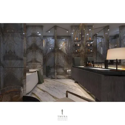 This bathroom is enveloped in dramatic, book-matched marble, creating a continuous, flowing pattern across the walls. The glass shower enclosure maintains the open feel, while the freestanding tub invites relaxation.