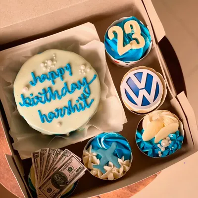A detailed look at the custom birthday set, featuring a Volkswagen logo cupcake and another with a white chocolate seashell and pearl decoration.