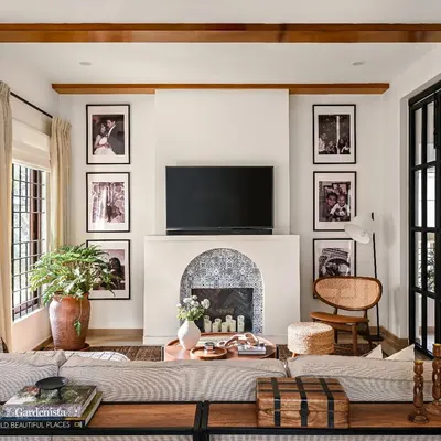This family room is designed for cozy movie nights and quality time. The large sectional faces the custom fireplace and TV unit, while the wooden ceiling beams and layered rugs add warmth and texture. It's a perfect example of a comfortable, lived-in luxury design.