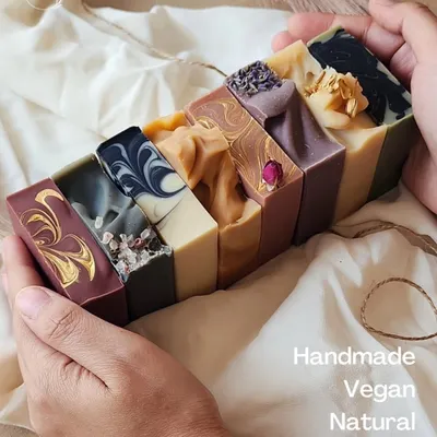 This is a handful of my art. I'm holding a loaf of freshly cut cold-process soaps, showing the unique colors, swirls, and textures of each natural, vegan, and handmade bar.