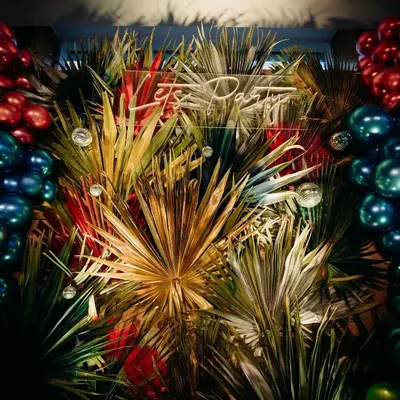 A detailed look at the vibrant, tropical-themed backdrop we created for Kushi Patil's 20th birthday. The arrangement featured lush greenery, metallic balloons, and a custom "Let's Party" neon sign that set a festive and stylish tone for the evening.