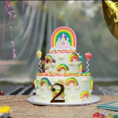 A fantastic rainbow-themed cake for a second birthday party. I always capture a beautiful shot of the cake before it's cut, preserving the memory of its creative design.