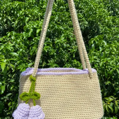 A beautiful custom shoulder bag in a neutral beige with a lovely lilac trim and tulip charm. This shows the kind of personalized work I can do for special orders.