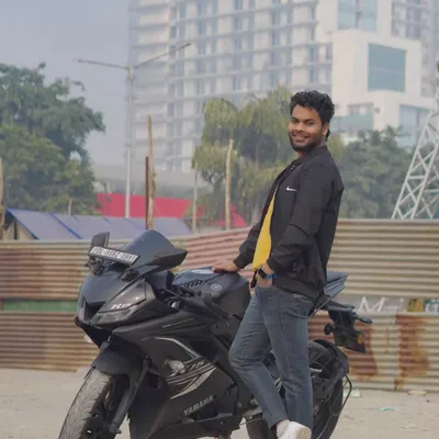 A full-length shot of the model standing next to his Yamaha R15. The urban background adds to the modern, cool feel of this men's portfolio photo.