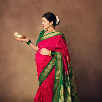 Holding a diya, a symbol of light and hope. This traditional maternity portrait is filled with grace and a sense of sacredness.